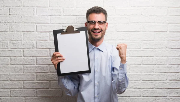 Young Adult Business Man Brick Wall Holding Clipboard Screaming Proud — Stock Photo, Image