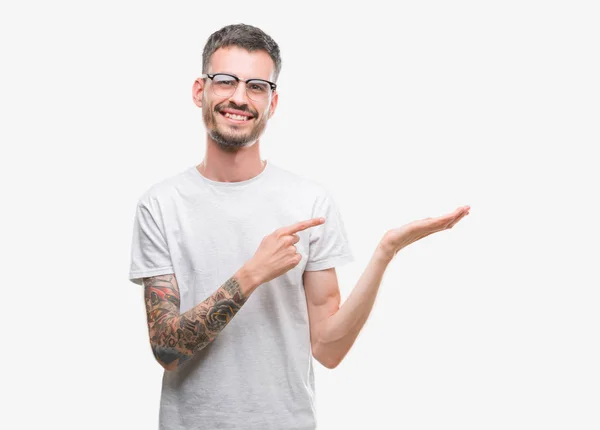 Young Tattooed Adult Man Amazed Smiling Camera While Presenting Hand — Stock Photo, Image