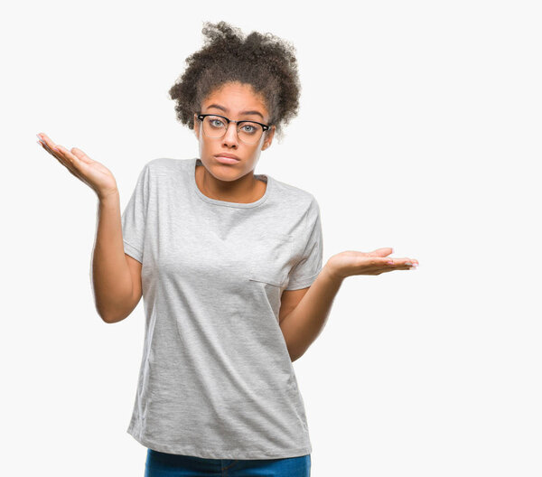 Young afro american woman wearing glasses over isolated background clueless and confused expression with arms and hands raised. Doubt concept.