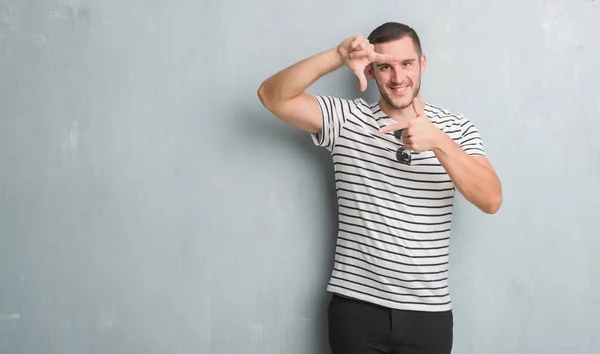 Homem Caucasiano Jovem Sobre Parede Grunge Cinza Sorrindo Fazendo Moldura — Fotografia de Stock