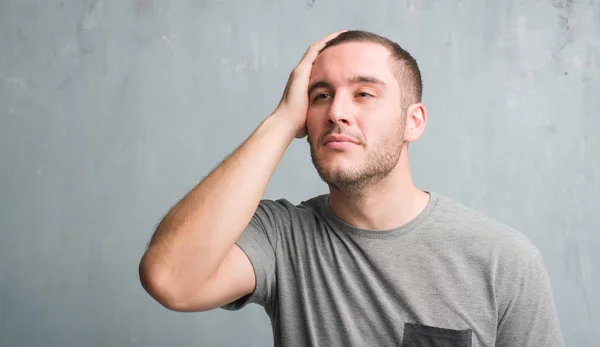 Joven Hombre Caucásico Sobre Pared Gris Grunge Estresado Con Mano — Foto de Stock