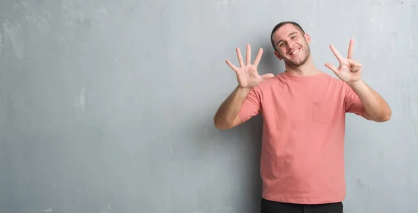 Homem Caucasiano Jovem Sobre Parede Grunge Cinza Mostrando Apontando Para — Fotografia de Stock