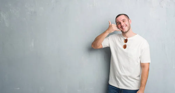 Joven Hombre Caucásico Sobre Pared Gris Grunge Usando Gafas Sol — Foto de Stock