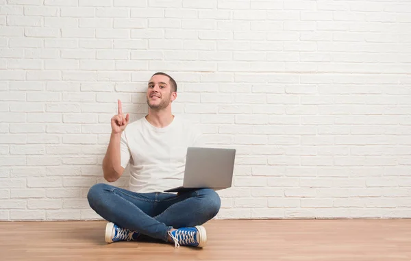 Giovane Uomo Caucasico Seduto Sopra Muro Mattoni Bianchi Utilizzando Computer — Foto Stock