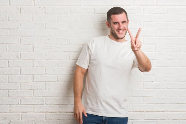 Joven Hombre Caucásico Pie Sobre Pared Ladrillo Blanco Sonriendo Mirando — Foto de Stock