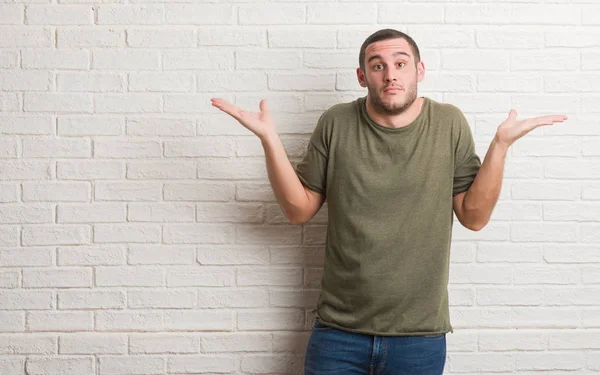 Joven Hombre Caucásico Pie Sobre Pared Ladrillo Blanco Expresión Despistado — Foto de Stock