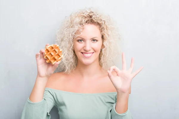 Unga Blonda Kvinnan Över Grunge Grå Bakgrund Äta Belgisk Våffla — Stockfoto