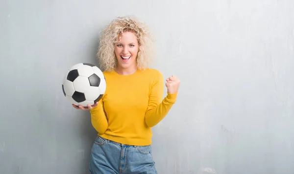 Junge Blonde Frau Über Grunge Grauem Hintergrund Hält Fußballball Schreiend — Stockfoto