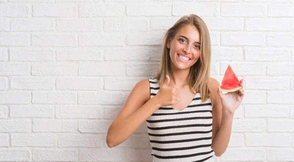 Vacker Ung Kvinna Över Vit Tegelvägg Äta Vatten Melon Bit — Stockfoto