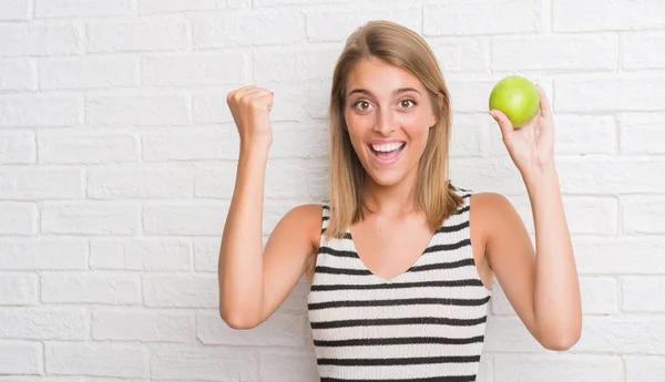 Hermosa Mujer Joven Sobre Pared Ladrillo Blanco Comiendo Manzana Verde —  Fotos de Stock