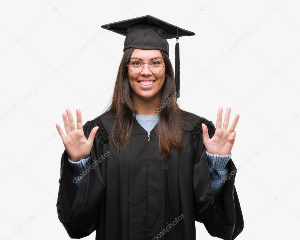 Young hispanic woman wearing graduated cap and uniform showing and pointing up with fingers number nine while smiling confident and happy.