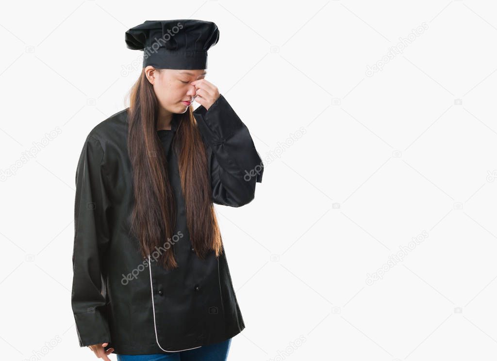 Young Chinese woman over isolated background wearing chef uniform tired rubbing nose and eyes feeling fatigue and headache. Stress and frustration concept.