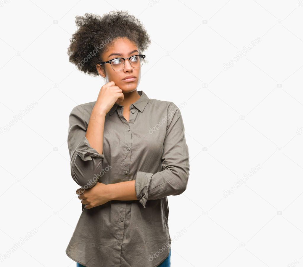 Young afro american woman wearing glasses over isolated background with hand on chin thinking about question, pensive expression. Smiling with thoughtful face. Doubt concept.