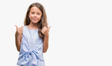 Esmer Latin kız başarı işareti başparmak gülümseyen ve mutlu el ile olumlu hareketi yapıyor. Neşeli bir ifadeyle, kazanan jest kameraya bakıyor.
