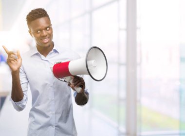 Megafon çok mutlu el ve parmak ile tarafına işaret tutan genç Afro-Amerikan adam