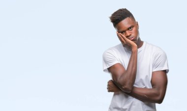 İzole arka plan düşünme seyir üzerinde genç Afro-Amerikan adam yorgun ve sıkılmış çapraz silah depresyon sorunları ile.