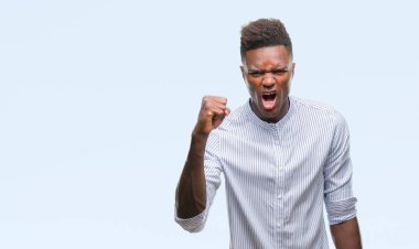 Afrikalı-Amerikalı genç izole arka plan öfkeli ve sinirli sinirli ve öfke ile bağırarak süre öfkeli yumruk yükselterek üzerinde. Öfke ve agresif kavramı.
