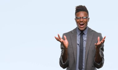 Genç Afro-Amerikalı iş adamı deli ve silah ile başarı için deli kutluyor izole arka plan üzerinde kaldırdı ve heyecanlı çığlık gözler kapalı. Kazanan kavramı