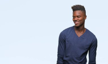 Afrikalı-Amerikalı genç uzak tarafına yüzünde, doğal ifade gülümseme ile seyir izole arka plan üzerinde. Kendine güvenen gülüyor.