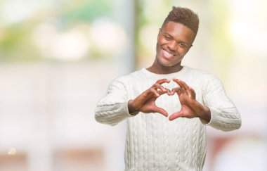 Afrikalı-Amerikalı genç aşık kalp simgesi ve elleriyle şekil gösteren gülümseyen izole arka plan üzerinde. Romantik kavramı.