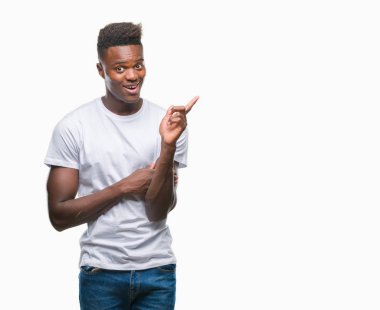 Kameraya bakarak yan el ve parmak ile işaret eden genç Afro-Amerikan adam yüzünde kocaman bir gülümseme ile izole arka plan üzerinde.