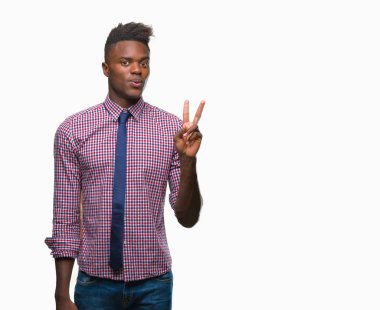 Mutlu yüz zafer işareti yaparken kameraya göz kırpıyor ile gülümseyen izole arka plan üzerinde genç Afro-Amerikalı iş adamı. İki numaralı.