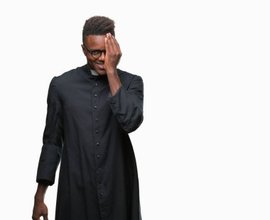 El yüz ve sürpriz duygu kendinden emin gülümseme ile tek gözüyle kapsayan izole arka plan genç Afro-Amerikan rahip adam.