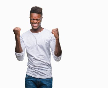 Gülümseyen ve başarı için çığlık genç Afro-Amerikan adam izole arka plan çok mutlu ve heyecanlı kaldırdı, silah ile kazanan jest yapıyor. Kutlama kavramı.