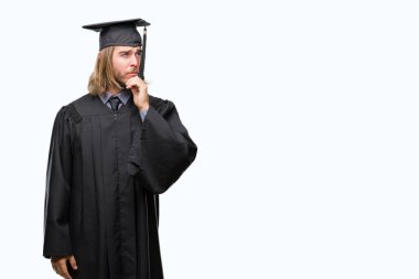 Genç yakışıklı adam uzun saçlı çene düşünme hakkında soru, dalgın ifade üzerine el ile izole arka plan üzerinde mezun oldu. Düşünceli yüzüyle gülümsüyor. Şüphe kavramı.