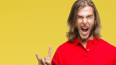 Yakışıklı delikanlı deli ifade rock simge elle yapıyor ile bağırarak izole arka plan üzerinde uzun saçlı. Müzik yıldızı. Ağır kavramı.