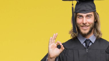 Genç yakışıklı adam uzun saçlı derecesi parmak, mükemmel sembolü ile ok işareti yapıyor izole arka plan üzerinde tutarak yüksek lisans