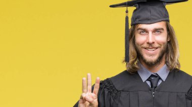 Gösterilen ve parmakları ile işaret izole arka plan üzerinde uzun saçlı Genç mezun yakışıklı üçüncü ise kendinden emin ve mutlu gülümseyerek.