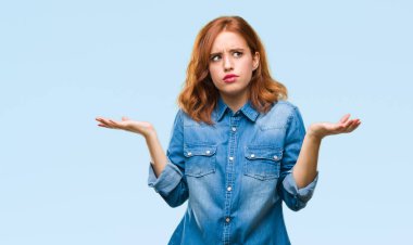 İzole arka plan clueless ve şaşkın bir ifadeyle kollar ve eller kaldırdı genç güzel kadın. Şüphe kavramı.