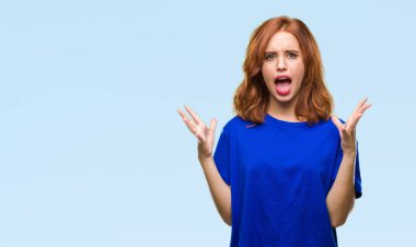 Genç güzel kadın deli kutluyor ve silah ile başarı için heyecanlı çığlık kaldırdı ve açık gözleri hayret izole arka plan yüzünden. Kazanan kavramı