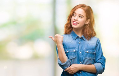 Seyir ve başparmak yanında yukarıyı mutlu yüz ile gülümseyen izole arka plan üzerinde genç güzel kadın.