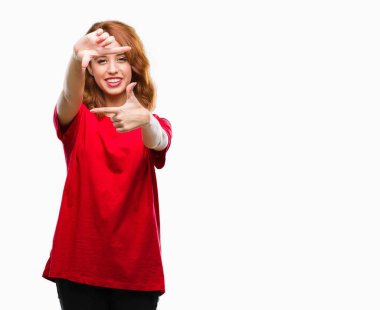 Genç güzel kadın elle yapma çerçeve ve parmakları ile mutlu yüz gülümseyen izole arka plan yüzünden. Yaratıcılık ve Fotoğrafçılık kavramı.