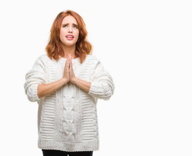 İzole arka plan yalvarıyor ve umut ifade yüzünde çok duygusal ve endişe ile birlikte elleriyle dua kış kazak giyen genç güzel kadın. Bağışlanmak. Din kavramı.