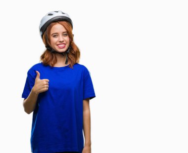 Genç güzel kadın hareketi el ile mutlu yaşasın yapıyor izole arka plan üzerinde bisikletçi kask giyiyor. Kameraya bakarak başarı gösteren ile ifade onaylama.