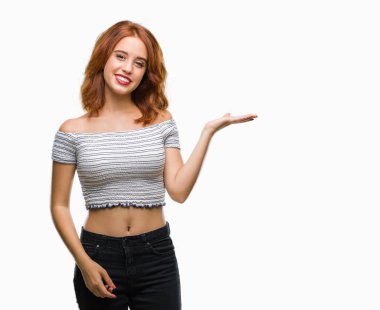 Neşeli sunulması ve kameraya bakarak avucunun ile işaret gülümseyen izole arka plan üzerinde genç güzel kadın.