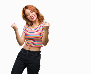 Gülümseyen ve başarı için çığlık genç güzel kadın izole arka plan çok mutlu ve heyecanlı kaldırdı, silah ile kazanan jest yapıyor. Kutlama kavramı.