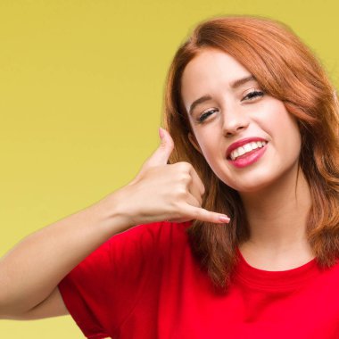 Genç güzel kadın yapıyor gülümseyen izole arka plan üzerinde telefon hareketi ile el ve parmak telefonda konuşuyor gibi. Kavramları iletişim.