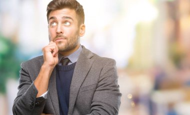 Genç yakışıklı iş adamı çene düşünme hakkında soru, dalgın ifade üzerine el ile izole arka plan üzerinde. Düşünceli yüzüyle gülümsüyor. Şüphe kavramı.