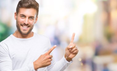 Yakışıklı delikanlı gülümseyen ve iki elleri ve parmakları ile tarafına işaret kamera bakarak izole arka plan üzerinde.