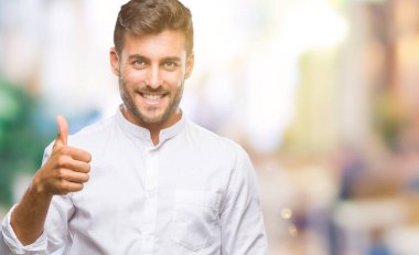 Yakışıklı delikanlı hareketi el ile mutlu yaşasın yapıyor izole arka plan üzerinde. Kameraya bakarak başarı gösteren ile ifade onaylama.