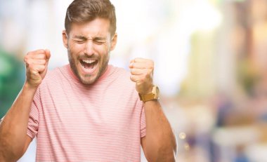 Yakışıklı delikanlı izole arka kolları olan başarı için heyecan üzerinde zafer kutluyor gülümseyen kaldırdı. Kazanan kavramı.