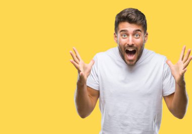 Yakışıklı delikanlı deli kutluyor ve silah ile başarı için heyecanlı çığlık kaldırdı ve açık gözleri hayret izole arka plan üzerinde. Kazanan kavramı