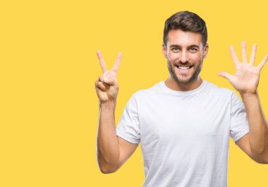 Yakışıklı delikanlı gösterilen ve parmakları ile işaret izole arka plan üzerinde kendinden emin ve mutlu gülümseyerek süre yedi numara.