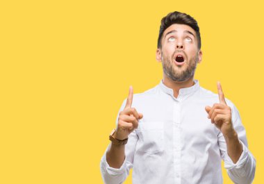 Yakışıklı delikanlı izole arka plan üzerinden hayran ve yukarıya bakıp parmakları ile işaret şaşırttı ve silah kaldırdı.