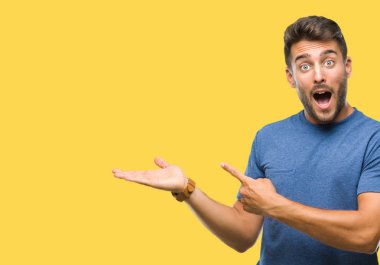 Yakışıklı delikanlı üzerinden hayran ve el ile sunulması ve parmak ile işaret ederken kameraya gülümseyen izole arka plan.