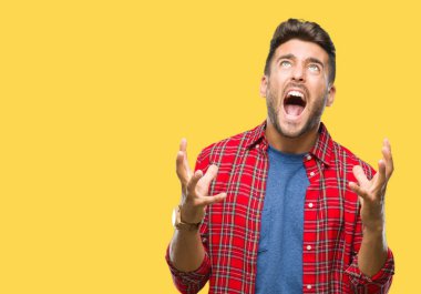 Genç yakışıklı adam izole arka plan çılgın ve kızgın bağırarak ve agresif ifade ve silah kaldırdı bağırıyor. Hayal kırıklığı kavramı.